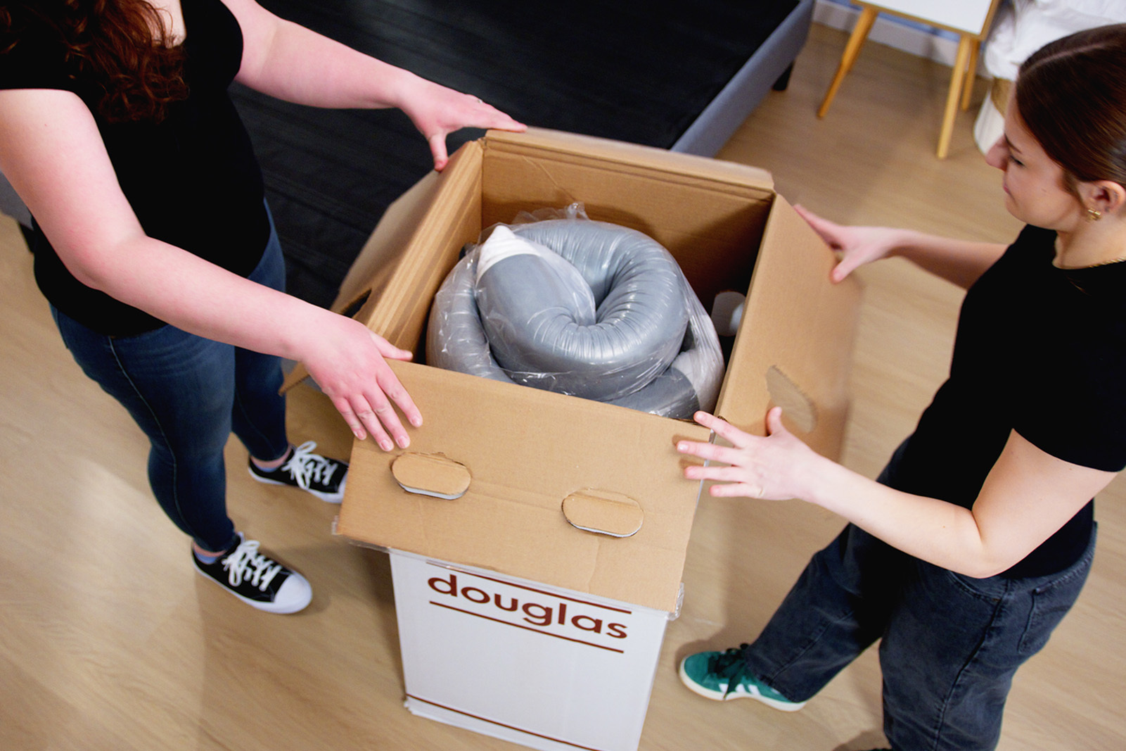 1601x1067 MattressReviewscom Two people opening up a boxed mattress in a bedroom