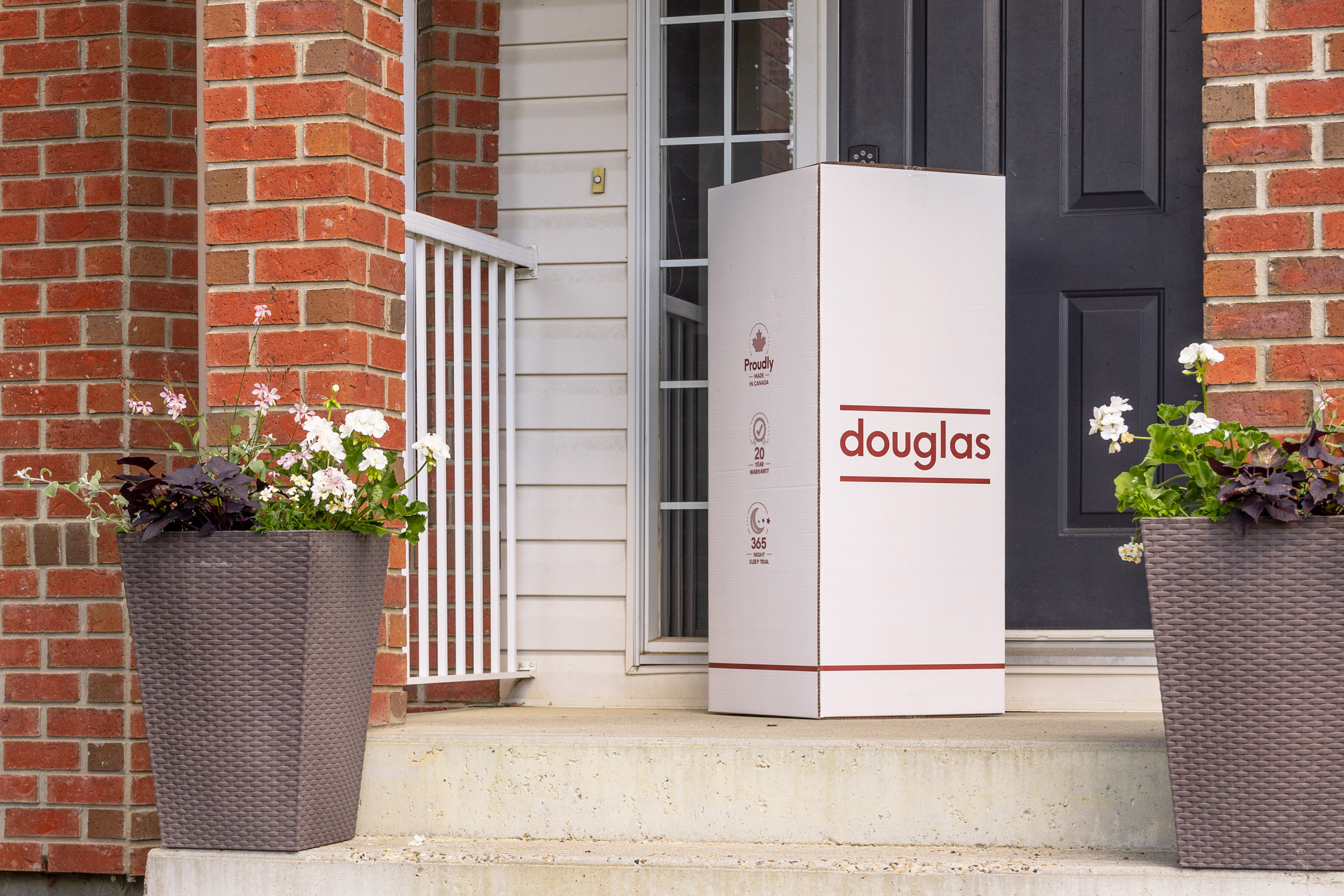 DGDoorstep1UpdatedBadges MattressReviewscom Image of a douglas mattress box being delivered on a front doorstep